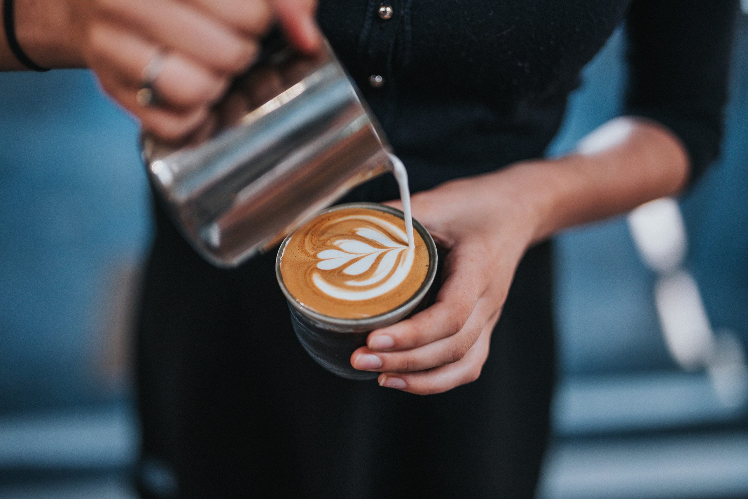 barista drawing latte art on third wave coffee movement