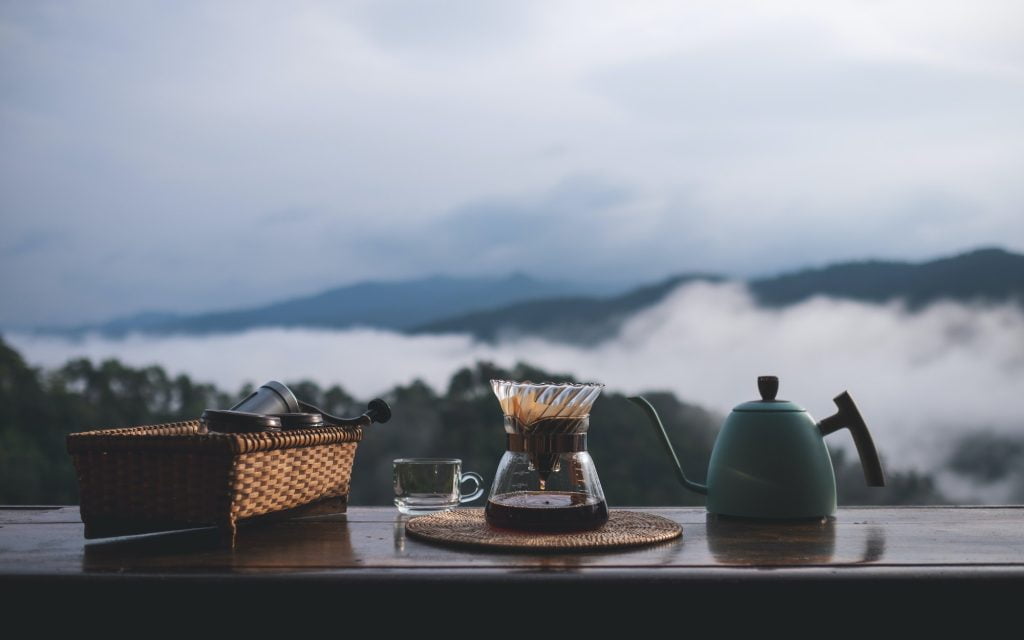 A set of coffee drip equipment with mountain and nature view on foggy day