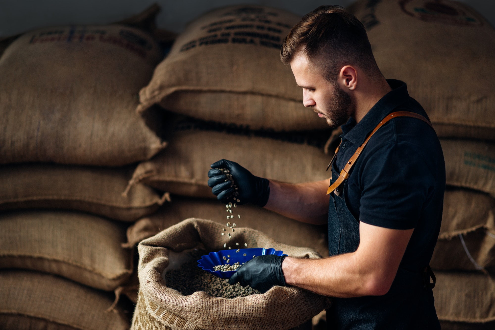 man pouring coffee from a bag into a bowl for tasting