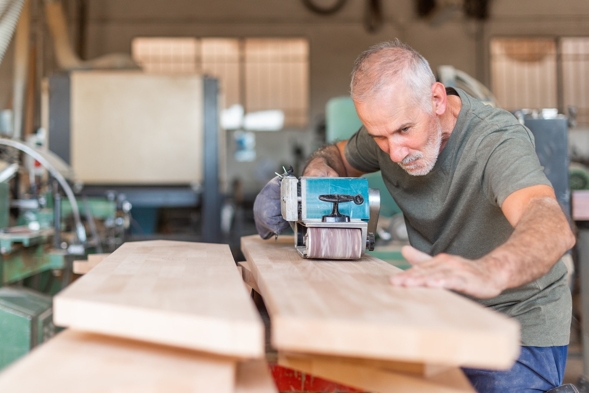 Person working with a hand sander checking the plank